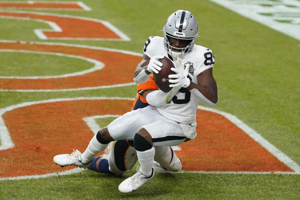 Las Vegas Raiders wide receiver Bryan Edwards (89) catches a pass for a touchdown over Denver Broncos cornerback Parnell Motley during the first half of an NFL football game, Sunday, Jan. 3, 2021, in Denver. (AP Photo/David Zalubowski)
