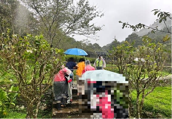 李姓女遊客前往宜蘭明池遊樂區欣賞環湖景色，因天雨路滑不慎跌倒，撞擊步道旁水泥樁，致右手臂及腰部均有擦挫傷，在明池警派出所所長蘇明勝及警員蔣銀星攙扶戒護送下山。（三星警分局提供）