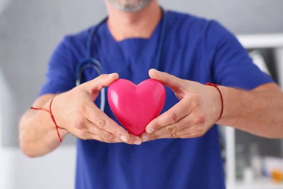 Doctor holding a heart symbol in his hands