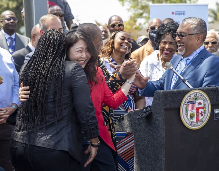 LOS ANGELES, CA-APRIL 29, 2022: Shinese Harlins-Kilgore, left, back to camera, cousin of Latasha Harlins, hugs Hyepin Im, President and Founder of Faith and Community Empowerment during a press conference at the intersection of Florence Ave. and Normandie Ave in Los Angeles on the 30th anniversary of the L.A. Riots. In background, center is Lora Dene King, daughter of Rodney King, and at far right is Robert Saucedo, President and CEO of Community Build. 2nd from right is former Congresswoman Diane Watson, (Mel Melcon / Los Angeles Times)