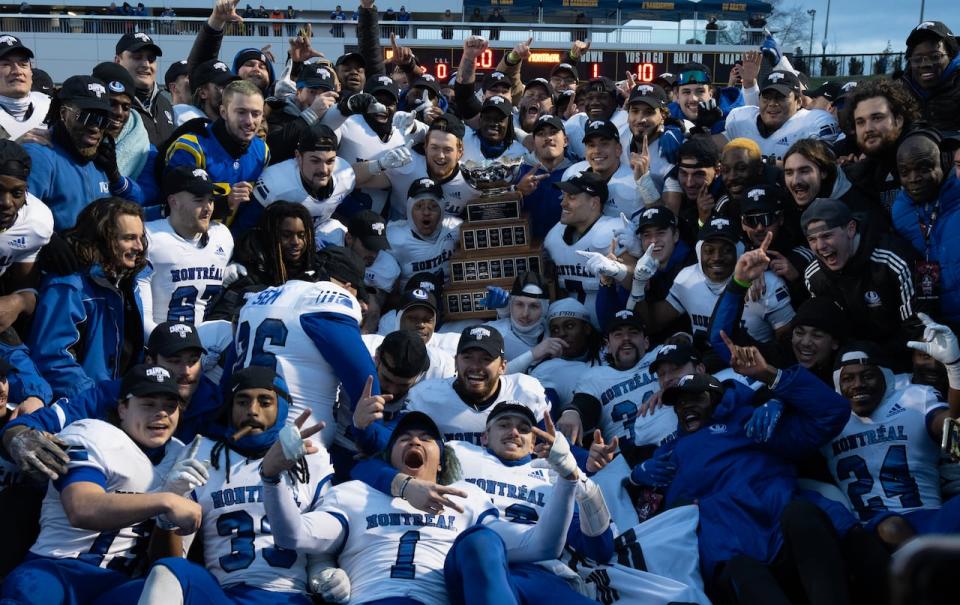 Members of the Montreal Carabins celebrate with the Vanier Cup on Saturday in Kingston, Ont. The Carabins defeated the UBC Thunderbirds 16-9 to win the Canadian University Football Championship. (Adrian Wyld/The Canadian Press - image credit)