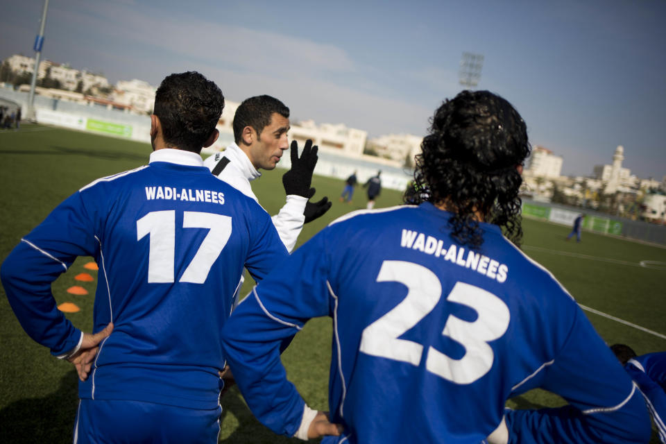 In this Friday Feb. 7, 2014 photo, Wadi al-Nees players warm up before a league game at a stadium in Hebron, West Bank. Palestinian farmer Yousef Abu Hammad sired enough boys for a soccer team and the current roster of the Wadi al-Nees team includes six of Abu Hammad's sons, three grandsons and five other close relatives. Wadi al-Nees heads the West Bank's 12-team “premier league,'' consistently defeating richer clubs and believe their strong family bonds are a secret to their success. (AP Photo/Dusan Vranic)