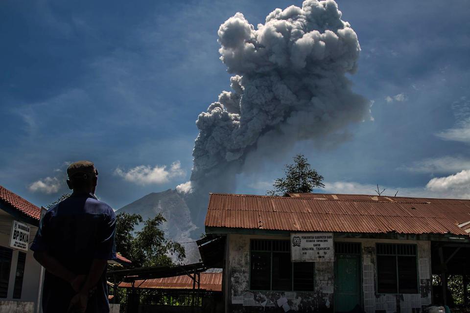 A resident watched as Sinabung volcano spews