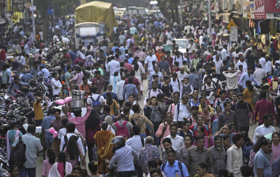 A crowd walks in a market area outside Dadar station in Mumbai, India, Friday, March 17, 2023. India will soon eclipse China to become the world's most populous country, and its economy is among the fastest-growing. But the number of Indian women in the workforce, already among the 20 lowest in the world, has been shrinking for decades. (AP Photo/Rajanish Kakade)