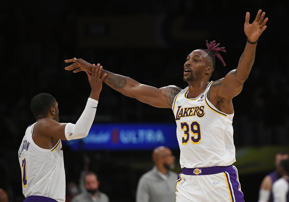 Los Angeles Lakers forward Carmelo Anthony (7) gives a high five to Los Angeles Lakers center Dwight Howard (39) in the first half of a preseason NBA basketball game against the Phoenix Suns in Los Angeles, Sunday, Oct. 10, 2021. (AP Photo/John McCoy)