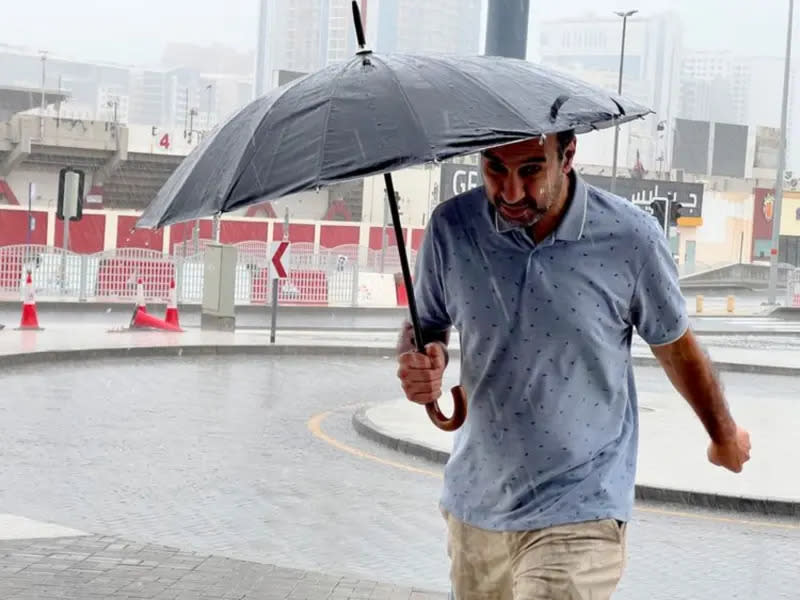 ▲阿拉伯聯合大公國（UAE）當地時間2日再次降下豪雨，圖為當天杜拜居民撐傘行走。（圖／翻攝自Gulf News）