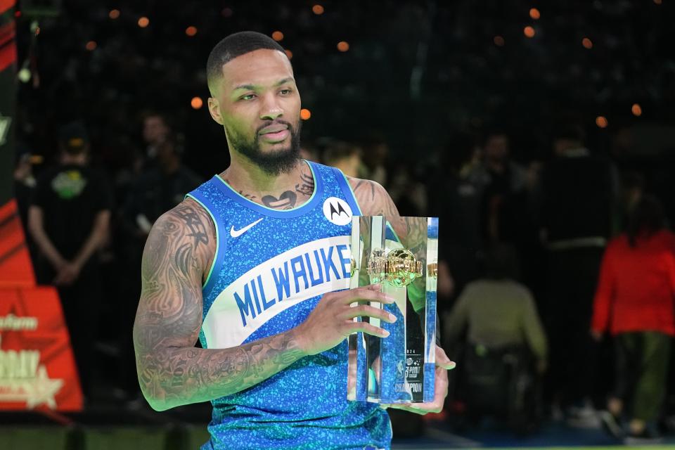 Milwaukee Bucks' Damian Lillard holds the trophy after winning the 3-point contest at the NBA basketball All-Star weekend, Saturday, Feb. 17, 2024, in Indianapolis. (AP Photo/Darron Cummings)