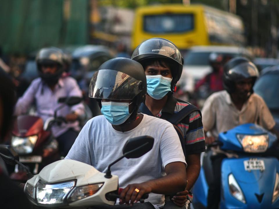 Ciudadanos usan cubrebocas camino al trabajo en medio de un aumento de los casos de covid-19 en Chennai, India (EPA)