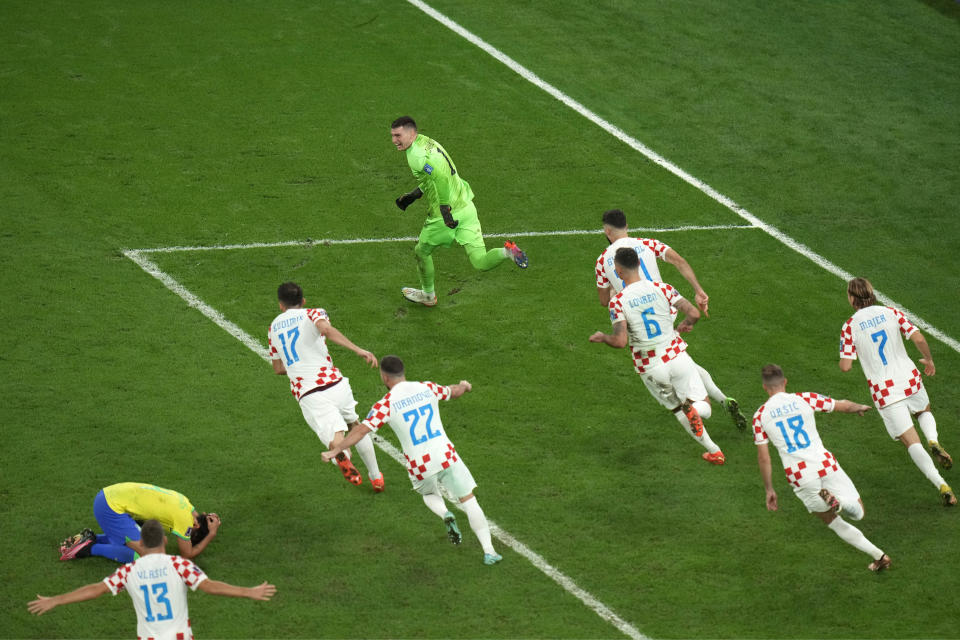 Brazil's Marquinhos, left, reacts as Croatian players celebrate after their win in the World Cup quarterfinal soccer match between Croatia and Brazil, at the Education City Stadium in Al Rayyan, Qatar, Friday, Dec. 9, 2022. (AP Photo/Alessandra Tarantino)