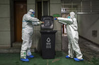 FILE - In this Sunday, Jan. 26, 2020, file photo, ambulance crew members dispose of protective gear in Wuhan in central China's Hubei Province. As Beijing instates one of the largest quarantines in modern history, locking down over 50 million people in Hubei province, questions are swirling around the provincial government's sluggish initial response. (Chinatopix via AP, File)