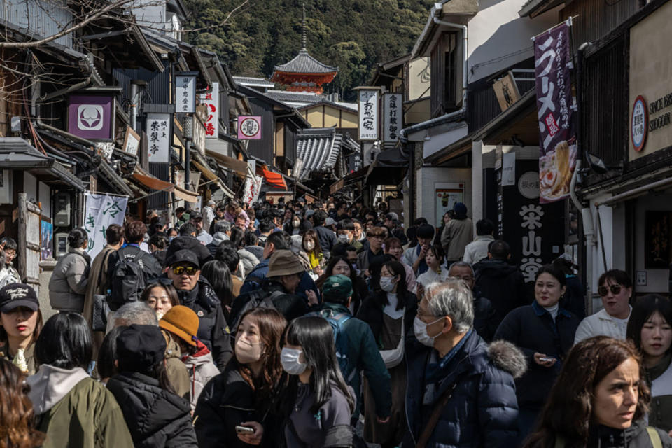 In this picture taken on March 10, 2024, crowds of people people walk through a street near Kiyomizu-dera Temple in Kyoto.