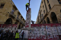 FILE - A team of engineers removes a concrete wall from a road that leads to the parliament building, which were set up following nationwide protests that erupted in late 2019 amid an economic meltdown, in Beirut, Lebanon, Monday, May 23, 2022. Thirteen independent newcomers won seats in parliament in May 15 elections, building on the protest movement seeking to break the long domination by traditional parties. But the reform movement is fragmented and the challenges it faces in fighting an entrenched, sectarian-based ruling clique are enormous.. (AP Photo/Hassan Ammar, File)