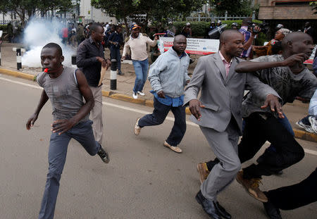 Supporters of Kenya's opposition Coalition for Reforms and Democracy (CORD) run away after riot police lobbed teargas canisters to disperse them during a protest at the premises hosting the headquarters of Independent Electoral and Boundaries Commission (IEBC) to demand the disbandment of the electoral body ahead of next year's election in Nairobi, Kenya, May 23, 2016. REUTERS/Goran Tomasevic