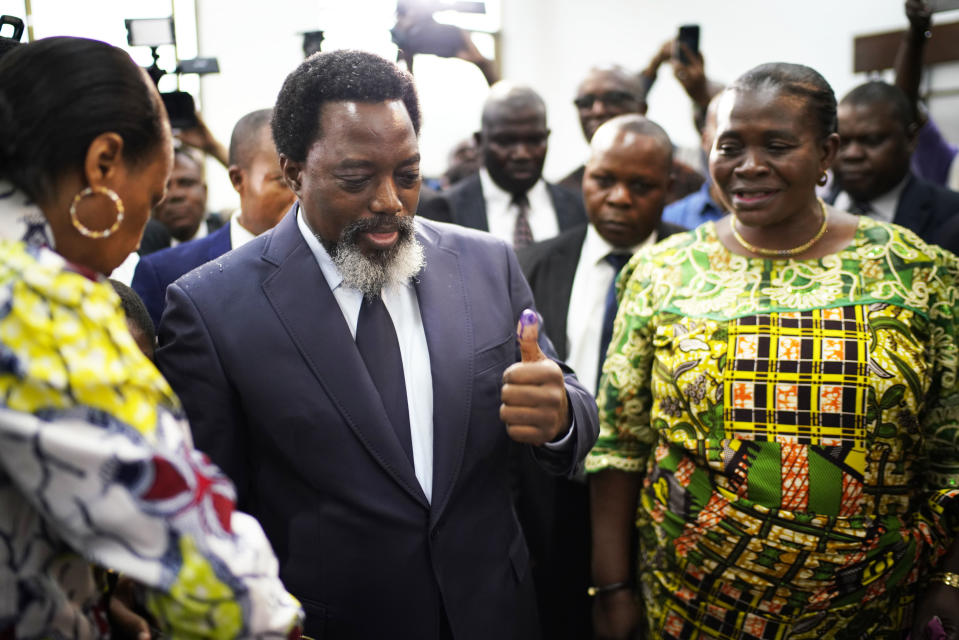 Congolese President Joseph Kabila, center, leaves the polling station after casting his vote Sunday, Dec. 30, 2018 in Kinshasa, Congo. Forty million voters are registered for a presidential race plagued by years of delay and persistent rumors of lack of preparation. (AP Photo/Jerome Delay)