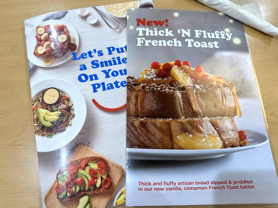 IHOP menu with pictures of french toast and other breakfasts on wood table