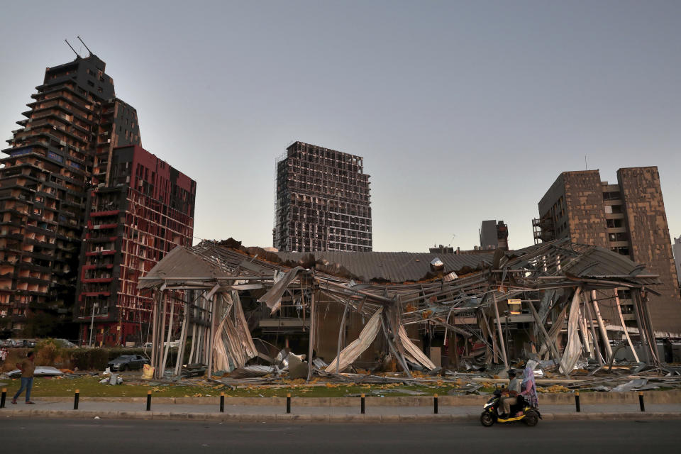 A couple on a scooter pasts buildings that were damaged after a massive Aug. 4 explosion that hit the seaport of Beirut, Lebanon, Sunday, Aug. 16, 2020. (AP Photo/Bilal Hussein)