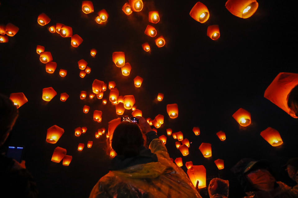 People take pictures as lanterns during the annual Pingxi Sky Lantern Festival, in Taiwan, 15 February 2022. (Photo by Ceng Shou Yi/NurPhoto via Getty Images)