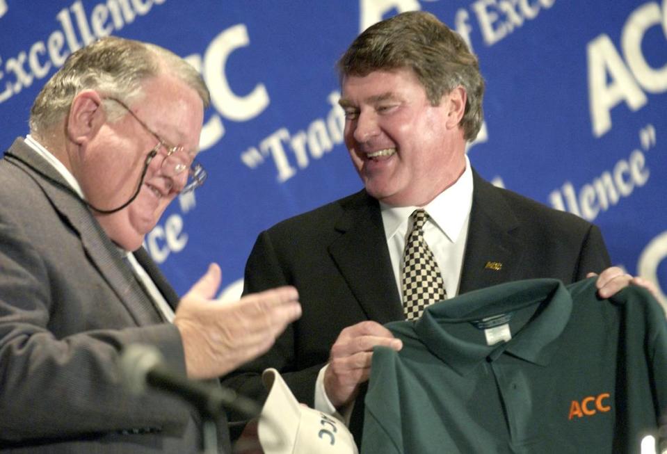 University of Miami Director of Athletics Paul Dee, left, jokes around with ACC Commissioner John Swofford while accepting a Hurricane colored ACC shirt during a press conference at the Grandover Resort & Conference Center in Greensboro in 2003. The ACC officially announced the addition of Virginia Tech and the University of Miami to the conference. News & Observer file photo