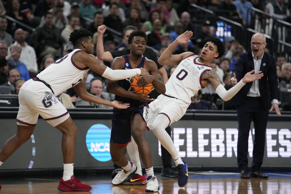 UConn guard Nahiem Alleyne handles the ball while defended by Gonzaga guard Malachi Smith, left, and guard Julian Strawther (0) in the second half of an Elite 8 college basketball game in the West Region final of the NCAA Tournament, Saturday, March 25, 2023, in Las Vegas. (AP Photo/John Locher)
