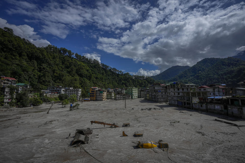 Vehicles lie submerged in mud in the flood affected area along the Teesta river in Rongpo, east Sikkim, India, Sunday, Oct. 8. 2023. Rescuers continued to dig through slushy debris and ice-cold water in a hunt for survivors after a glacial lake burst through a dam in India’s Himalayan northeast, shortly after midnight Wednesday, washing away houses and bridges and forcing thousands to flee. (AP Photo/Anupam Nath)