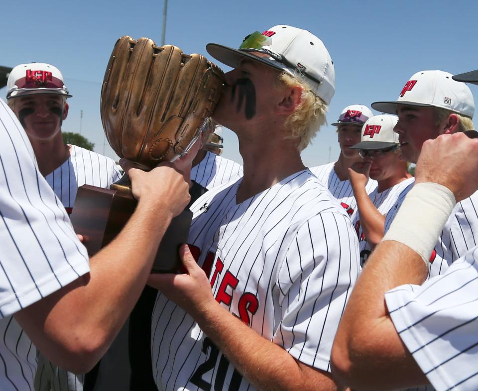 Lubbock-Cooper's Skyler White kisses the region quarterfinal champions trophy, Saturday, May 21, 2022, at Wilder Park at Wayland Baptist University in Plainview. Lubbock-Cooper won, 9-1.