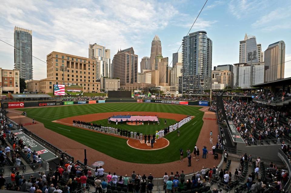 The Charlotte, NC skyline provides the backdrop as fans stand for the National Anthem at Truist Field on Tuesday, April 2, 2024. The Charlotte Knights hosted the Norfolk Tides in their 2024 home opener,