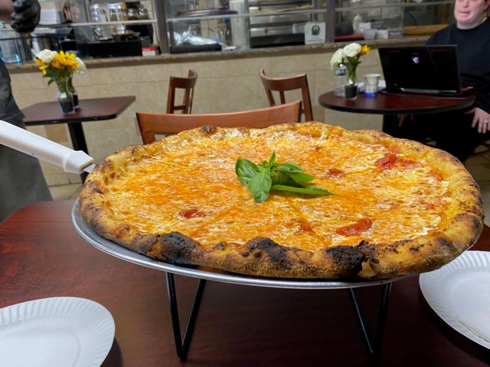 Voila! Marcello Segura serves up a cheese pie he crafted at his pizzeria,  Grumpy's, located in Saddle Brook.