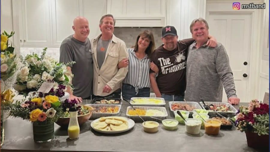 A picture posted to Instagram by the band shows all five members smiling in front of “get well soon” bouquets and sharing food together.