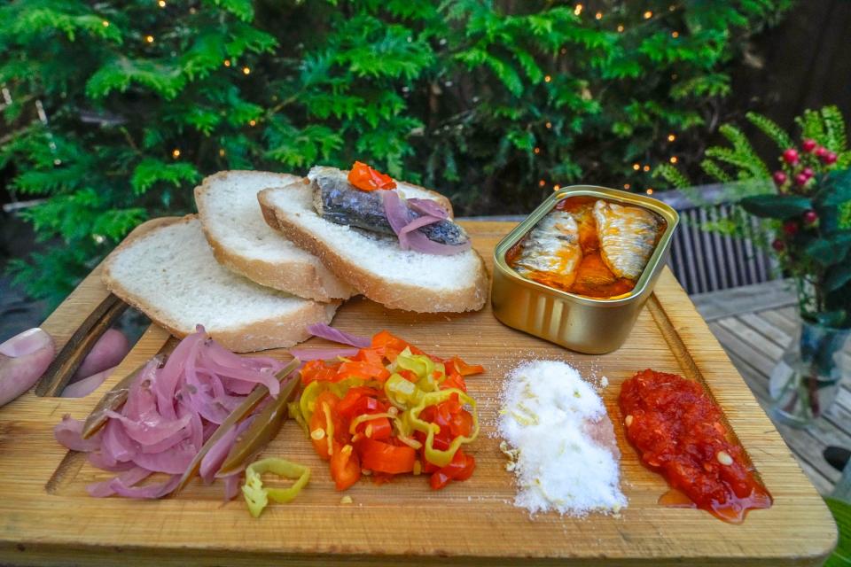 Tinned fish boards at Aguardente are served with accompaniments of bread, lemon zest, salt, red pickled onions and pepperoncini.