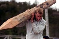 <p>Prince William carrying a log used to construct walkways linking buildings in the village of Tortel, Southern Chile during his Raleigh International expedition in December 2000. (AFP)</p> 