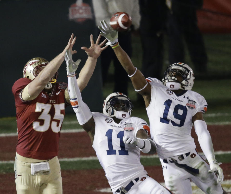 Auburn's Ryan White (19) and Chris Davis (11) break up a pass intended for Florida State's Nick O'Leary (35) during the first half of the NCAA BCS National Championship college football game Monday, Jan. 6, 2014, in Pasadena, Calif. (AP Photo/Gregory Bull)