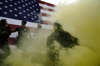 Members of the Proud Boys speak on stage as smoke flies in the air at a rally with other right-wing demonstrators on Saturday, Sept. 26, 2020, in Portland, Ore. (AP Photo/John Locher)