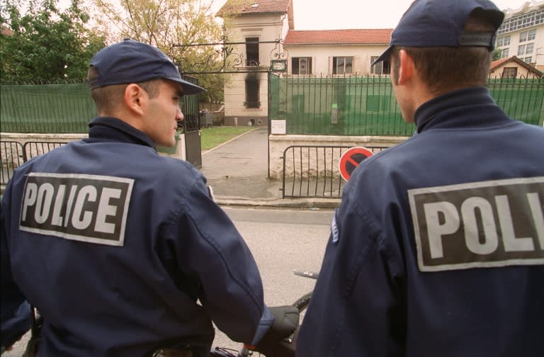 Policemen stand in front of a synagogue in Bondy, an eastern suburb of Paris after the synagogue was set alight by firebombs in 2000