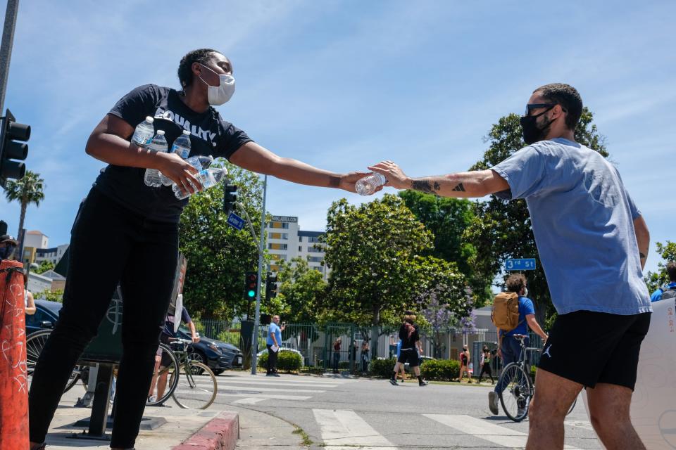 Siana Daniel hands out water to protestors in Los Angeles. Photo by Stacey Leasca.