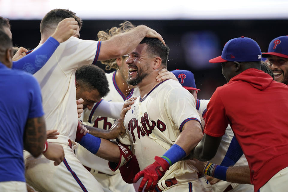 Philadelphia Phillies' Kyle Schwarber celebrates with teammates after hitting a game-winning RBI-sacrifice fly against San Diego Padres relief pitcher Tim Hill during the 12th inning of a baseball game, Sunday, July 16, 2023, in Philadelphia. (AP Photo/Matt Slocum)