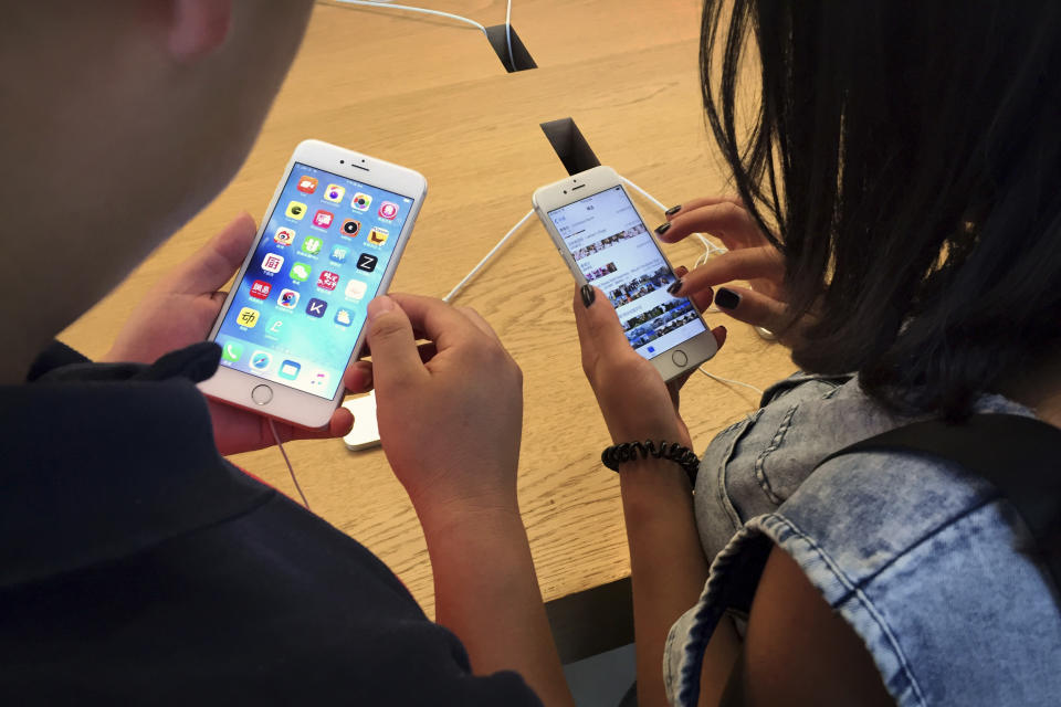 FILE - In this Saturday, June 18, 2016, file photo, customers try out Apple iPhone 6s models on display at an Apple Store in Beijing. New documents from WikiLeaks, posted Thursday, March 23, 2017, point to an apparent CIA program to hack Apple’s iPhones and Mac computers such that the exploits persist even after the devices are reset to factory conditions. Apple says the purported hacking techniques have all been fixed in recent iPhones and Mac computers. (AP Photo/Mark Schiefelbein, File)