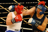 <p>Brian Fielder (red) exchanges punches with Brian Huang (blue) in the ring during a grudge match in the NYPD Boxing Championships at the Hulu Theater at Madison Square Garden on March 15, 2018. (Gordon Donovan/Yahoo News) </p>