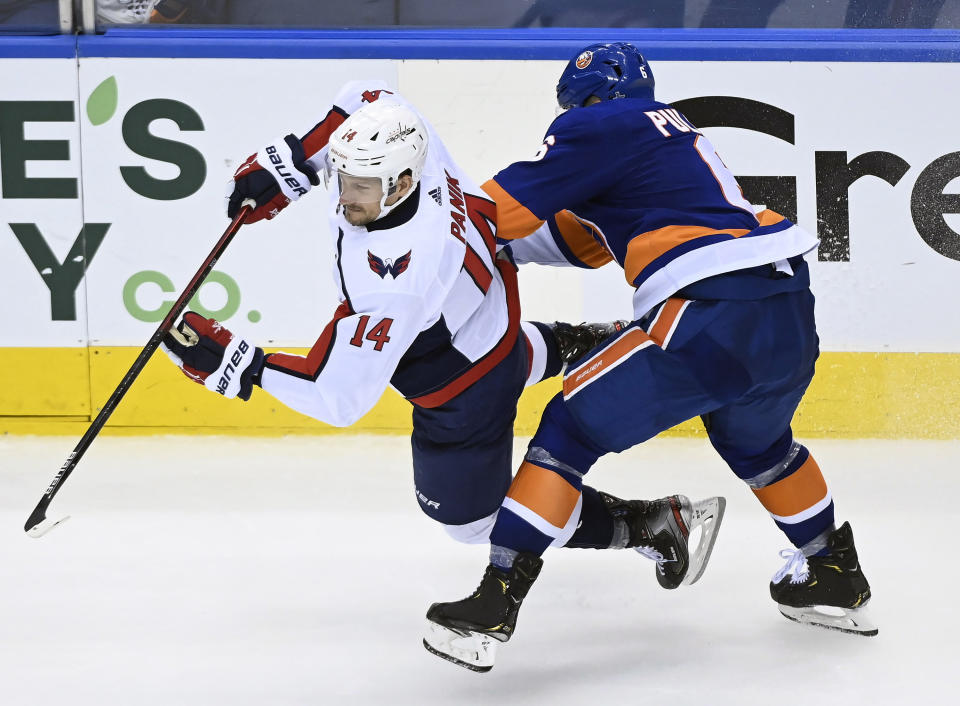 Washington Capitals right wing Richard Panik (14) is taken down by New York Islanders defenseman Ryan Pulock (6) during third-period NHL Eastern Conference Stanley Cup playoff hockey action in Toronto, Sunday, Aug. 16, 2020. (Nathan Denette/The Canadian Press via AP)