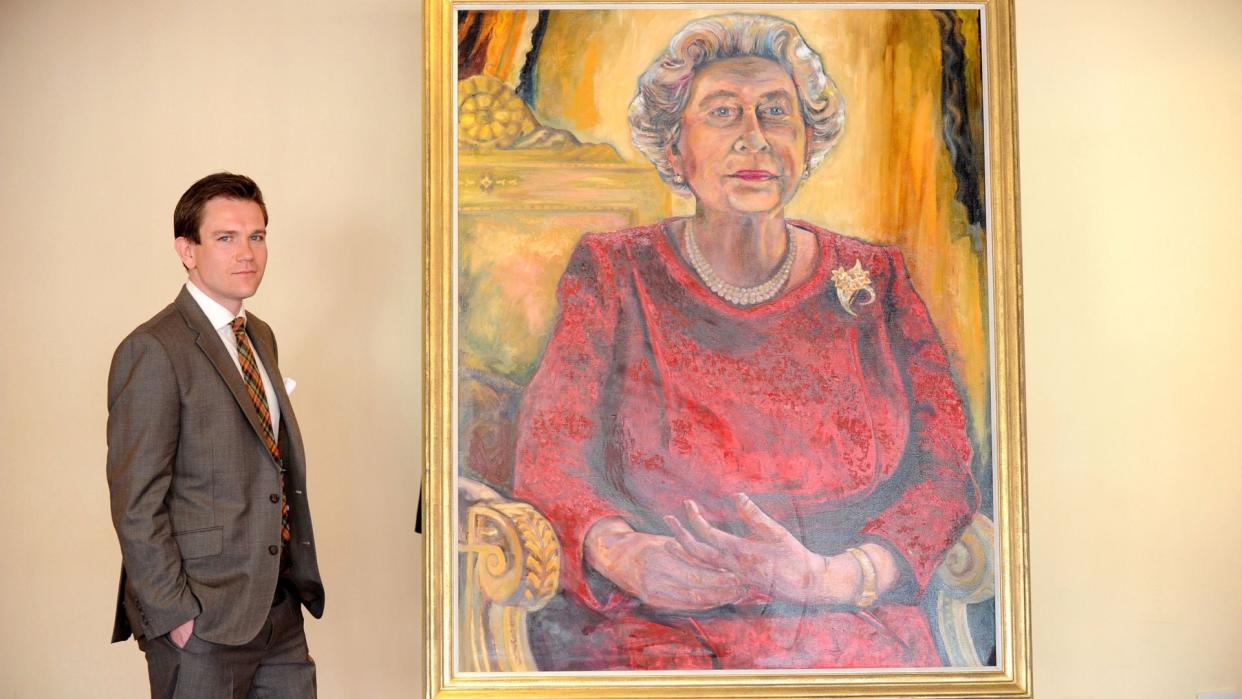 Daniel Llywelyn Hall con un retrato de Isabel II