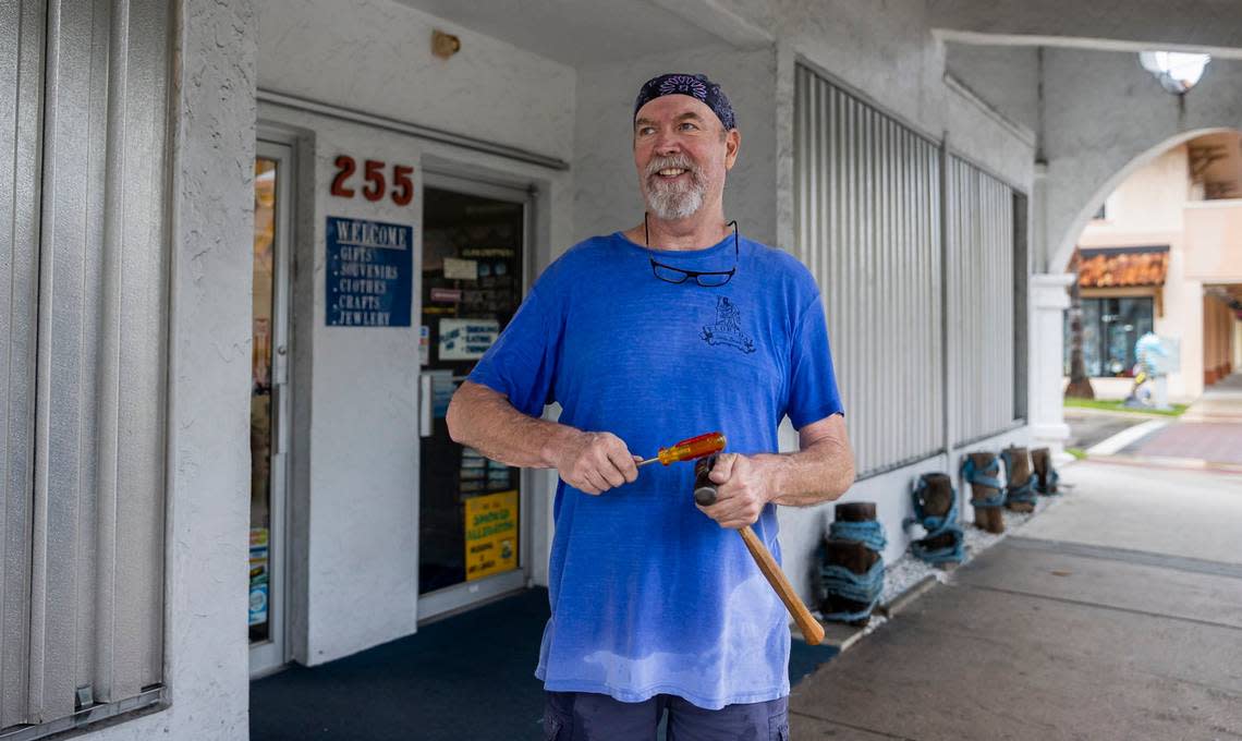 Daniel E. McDonald, 65, places shutters on his souvenir store, Sea Pleasures and Treasures, on Tuesday, Sept. 27, 2022, in Venice, Fla. Venice residents are preparing for the impacts of Hurricane Ian.