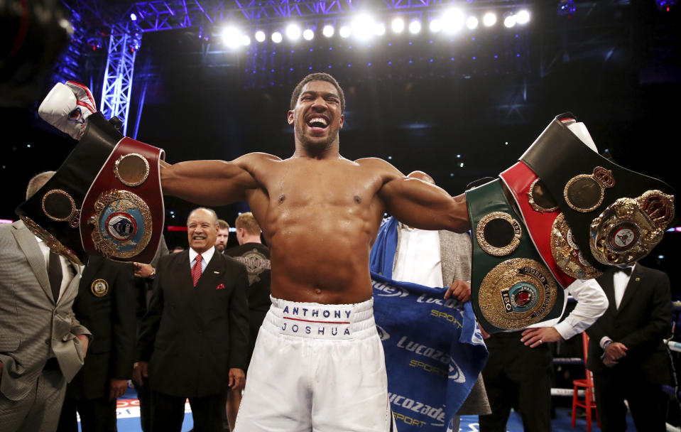 Anthony Joshua celebrates defeating Alexander Povetkin to retain his WBA, IBF and WBO heavyweight boxing titles Saturday at Wembley Stadium in London. (Nick Potts/PA via AP)