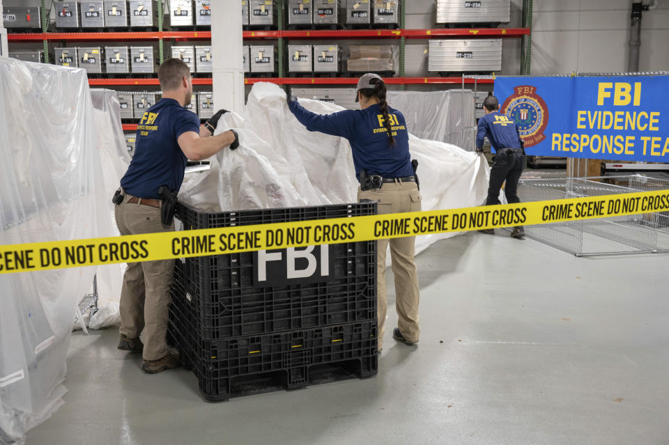In this image provided by the FBI, FBI special agents assigned to the evidence response team process material recovered from the high altitude balloon recovered off the coast of South Carolina, Thursday, Feb. 9, 2023, at the FBI laboratory in Quantico, Va., (FBI via AP)