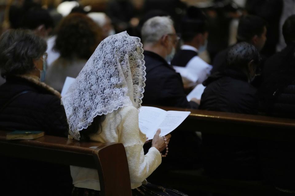 A faithful reads during a Latin Mass at Rome's ancient Pantheon basilica, in Rome, Italy, Friday, Oct. 29, 2021. Traditionalist Catholics descended on Rome on Friday for their annual pilgrimage, hoping to show the vibrancy of their community after Pope Francis issued a crackdown on the spread of the Latin Mass that many took as an attack on the ancient rite. An evening vespers service at Rome's ancient Pantheon basilica, the first event of the three-day pilgrimage, was so full that ushers had to add two rows of chairs to accommodate the faithful. Many young families, couples and priests filled the pews, hailing from the U.S., France, Spain and beyond. (AP Photo/Luca Bruno)
