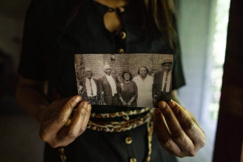 Angela Harrelson holds a photo of George Floyd's great-grandparents and other relatives.