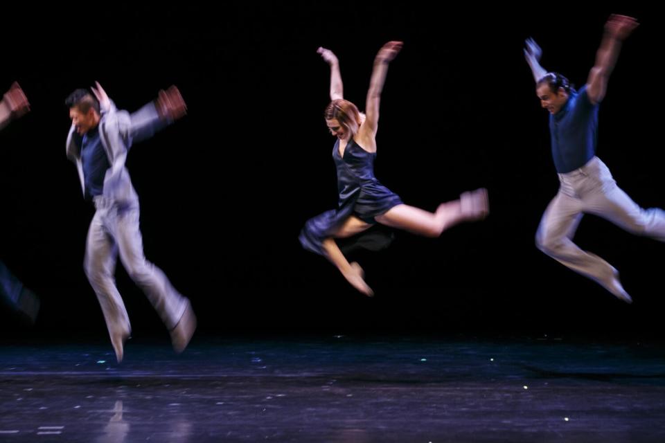 Dancers leaping onstage.