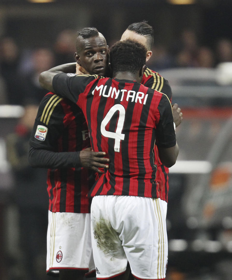 AC Milan forward Mario Balotelli, left, celebrates with his teammates Sulley Muntari, center, of Ghana, and Adil Rami, of France, after scoring during the Serie A soccer match between AC Milan and Bologna at the San Siro stadium in Milan, Italy, Friday, Feb. 14, 2014. (AP Photo/Antonio Calanni)