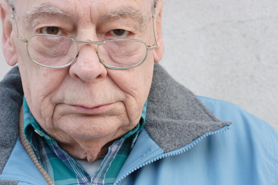 We see a close-up of an older man looking very displeased.