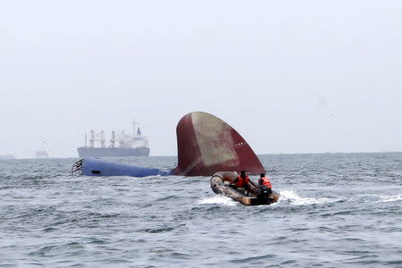 An Indonesia rescue team approaches the sunken Antigua and Barbuda flagged freighter MV Thorco Cloud which sank after colliding with a tanker the night before, in the Singapore Strait off the Indonesian island of Batam December 17, 2015 in this photo taken by Antara Foto. REUTERS/M N Kanwa/Antara Foto