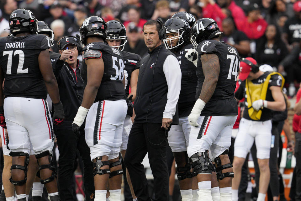 Cincinnati head coach Luke Fickell, center, looks on during a stoppage in play during the first half of an NCAA college football game against Navy, Saturday, Nov. 5, 2022, in Cincinnati. (AP Photo/Jeff Dean)