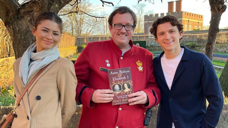 Tom and Zendaya smiling outside with another of the palace's staff, Tracy Borman